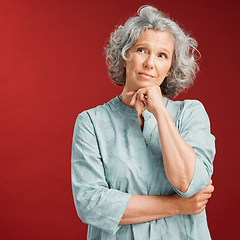 Image showing Mature woman thinking, making a decision or choice about what to wear with copy space. Confused senior caucasian female lost in her thoughts. Serious and uncertain retired lady choosing an option.