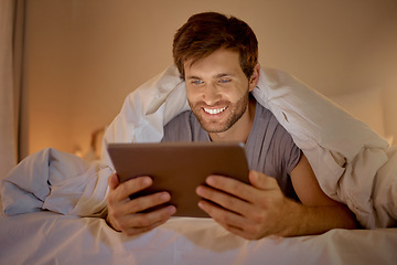 Image showing Happy man relaxing in bed with digital tablet watch, movie, series or online social media videos on an app. Browsing the internet news with 5g technology on wireless device in the bedroom at home