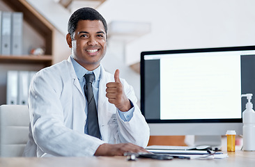 Image showing Doctor, medical practitioner and healthcare worker showing thumbs up for FDA or drug approval in a hospital with blank screen copy space on a computer. GP pleased with clinic success in his office