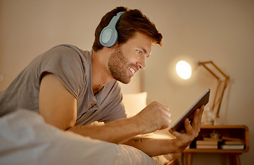 Image showing Headphones, digital tablet and in bed watching online movies, videos or series at night in house bedroom. Man on entertainment news or internet film streaming app or website on home 5g wifi network.