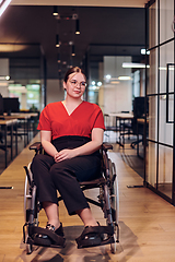 Image showing A modern young businesswoman in a wheelchair is surrounded by an inclusive workspace with glass-walled offices, embodying determination and innovation in the business world