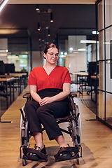 Image showing A modern young businesswoman in a wheelchair is surrounded by an inclusive workspace with glass-walled offices, embodying determination and innovation in the business world