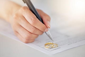 Image showing .Woman hand signing legal divorce documents, deal or paper contract in a lawyer office with ring placed on table. Person writing signature on marriage paperwork after agreement at family law office.