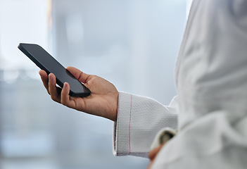 Image showing Karate student athlete hand texting message on a phone at sport gym and browsing the internet with online social media app. Networking on 5g wireless mobile device or smartphone on the web with wifi