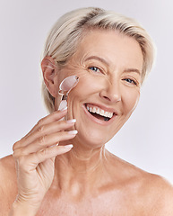 Image showing Mature, portrait and woman using rose roller on face for skincare massage and beauty spa routine. Feminine, selfcare and cosmetics for anti ageing facial treatment with white studio background.