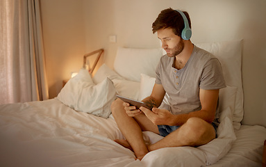 Image showing Headphones, digital tablet and in bed watching online movies, videos or series at night in house bedroom. Man on entertainment news or internet film streaming app or website on home 5g wifi network