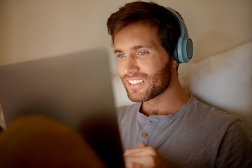 Image showing Man streaming movies online on digital tablet, watching series on technology in bedroom and listening to audio on headphones at night in bed at house. Person with smile reading social media post