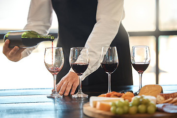 Image showing Luxury, fine dining and hospitality with a waiter pouring red wine at a restaurant. Preparing for a wine tasting with a professional sommelier, good service with quality drink by a male winemaker