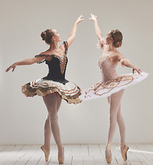 Image showing Ballerina, ballet dancer and creative performance, training rehearsal and choreography with en pointe technique on toes in dance studio. Graceful, elegant and beautiful women dancing in tutu costume