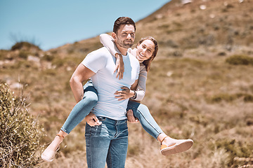 Image showing Happy and in love couple having fun in nature and enjoying quality time together. Cute and relax boyfriend piggyback or carrying girlfriend with a smile on a bonding and romantic countryside date