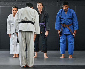 Image showing Karate coach teaching a fitness class at gym, students learning self defense training exercise with trainer and doing cardio workout at sports center. Healthy people doing martial arts hobby