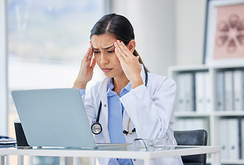 Image showing Stress or burnout with doctor thinking and working on laptop in hospital consulting room or office. Medical healthcare worker or specialist surgeon with anxiety headache from mental health issues