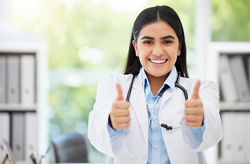 Image showing Excited medical doctor showing thumbs up for success working at hospital, giving support after and happy with service in an office at clinic. Portrait of healthcare worker showing winning hand sign