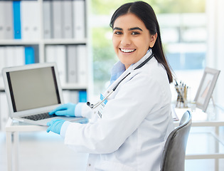 Image showing Doctor, smile and working on laptop mockup with medical healthcare employee at her desk in hospital consulting room or office. Medicine or wellness woman professional in clinic on internet database