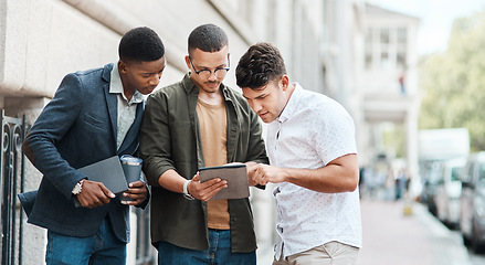 Image showing Team of creative designers checking a website for ux and ui while working for a startup. Group of young guys looking at a homepage on a tablet while developing a new business strategy or mission