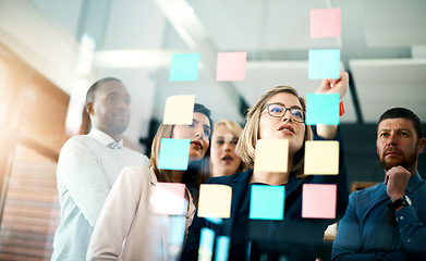 Image showing Creative group or business team planning for innovation with sticky notes on glass wall. Coach or leader sharing vision and mission in a meeting. Manager sharing ideas and explaining strategy