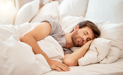 Image showing Relax, sleep and peace of a tired man sleeping in a bedroom bed at home. Dreaming, relaxing and resting calm attractive person with closed eyes on a pillow at his house in the morning taking a nap