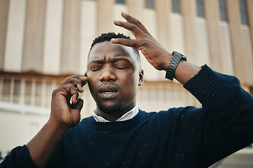 Image showing Tired, angry and stress business man talking on an annoying phone call outdoors in a city. Frustrated, pain or sick black male entrepreneur with a headache or migraine outside a urban town