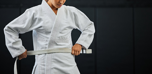 Image showing .Beginner, karate and student getting ready for the first day of self defense training against a dark background in a dojo. Determined learner in motivation for fighting lessons in the martial arts.