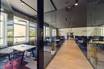 Image showing In a setting of modern, glass-walled business startup offices, the open, airy workspace reflects a contemporary and innovative ambiance, promising a dynamic environment for entrepreneurial growth