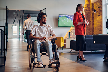 Image showing A businessman in a wheelchair occupies a hallway within a modern startup coworking center, embodying inclusivity and determination in the business environment