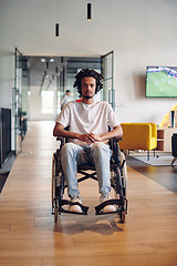 Image showing A businessman in a wheelchair occupies a hallway within a modern startup coworking center, embodying inclusivity and determination in the business environment