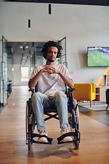 Image showing A businessman in a wheelchair occupies a hallway within a modern startup coworking center, embodying inclusivity and determination in the business environment