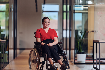 Image showing A modern young businesswoman in a wheelchair is surrounded by an inclusive workspace with glass-walled offices, embodying determination and innovation in the business world