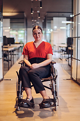 Image showing A modern young businesswoman in a wheelchair is surrounded by an inclusive workspace with glass-walled offices, embodying determination and innovation in the business world