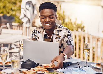Image showing Man working on a laptop while eating lunch at an outdoor restaurant with 5g service in the city. Casual employee doing research on internet with a computer while having sandwich and champagne at cafe