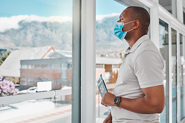 Image showing Man at airport with covid passport and mask for safety from a virus waiting for flight during international travel. Tourist standing at window to board airplane for vacation during corona pandemic