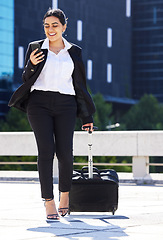 Image showing Business woman, travel with luggage and phone for communication with work, internet or web search. Corporate employee going to airport to catch plane for company tradeshow, conference or workshop