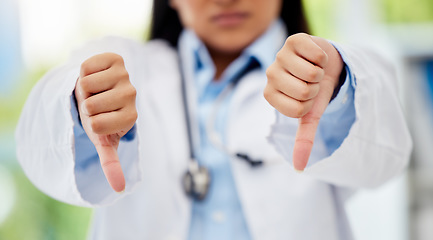 Image showing Doctor with thumbs down hand sign in healthcare hospital or lab for fail, poor health insurance or death statistics. Zoom of unhappy, bad loss or loser hands emoji icon of a healthcare professional