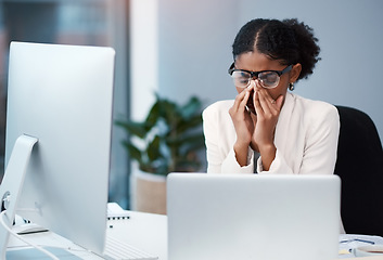 Image showing Sad unhappy business woman with headache, migraine or burnout working on a computer in an office alone at work. One tired, anxious and frustrated corporate female boss looking exhausted and upset