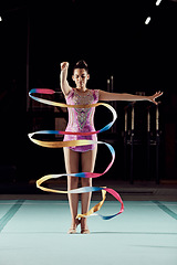 Image showing Ribbon dancer, woman and stage performance or practice at gym. Girl with flexibility does physical and artistic sports training. Balance, strong and gymnastic body of young athlete with discipline.