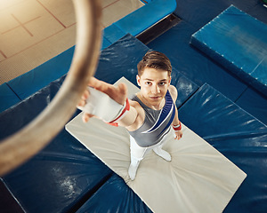 Image showing Sport, exercise and training ring for gymnastics exercise with a boy gymnast student in a gym. Top focus of an athlete about to do a fitness, wellness and sports workout to train for a performance