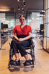 Image showing A modern young businesswoman in a wheelchair is surrounded by an inclusive workspace with glass-walled offices, embodying determination and innovation in the business world