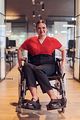 Image showing A modern young businesswoman in a wheelchair is surrounded by an inclusive workspace with glass-walled offices, embodying determination and innovation in the business world