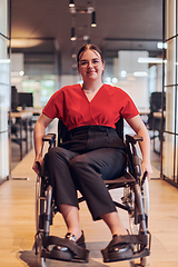 Image showing A modern young businesswoman in a wheelchair is surrounded by an inclusive workspace with glass-walled offices, embodying determination and innovation in the business world