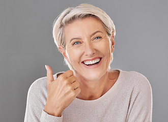 Image showing Skincare, wellness and thumbs up by happy mature woman smiling showing winning hand gesture against studio background. Senior support and recommend cosmetic surgery, treatment or product for wrinkles