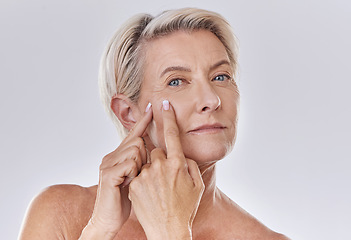 Image showing Acne or pimple popping senior woman while doing a skincare beauty treatment for healthy and clear skin. Portrait of happy old, mature or elderly female squeezing a spot on her face