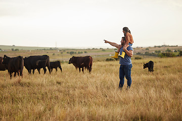 Image showing Sustainability, nature and farmer teaching daughter how to care for livestock on a cattle farm. Loving parent bonding with his little child, enjoying fresh outdoors together and having fun in field