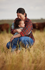 Image showing Love, family and care with a mother and daughter hugging in a field outside on a farm. Cattle farmer and little girl in the farming, agricultural and dairy industry on a meadow or pasture outdoors