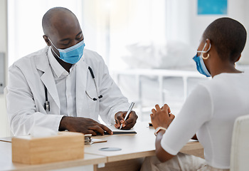 Image showing Doctor, office and writing a covid note or medical history, record or insurance paperwork for patient at work. Black healthcare professional man or GP signing documents for client with masks.