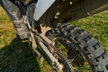 Image showing Close up photo of a professional motocross rider in action, showcasing the tire and various components of the motorcycle as they navigate the challenging off-road terrain with speed and precision.