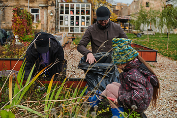 Image showing A modern family parents and children, is working together to beautify their front yard with flowers in preparation for the upcoming holiday season.