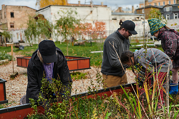 Image showing A modern family parents and children, is working together to beautify their front yard with flowers in preparation for the upcoming holiday season.