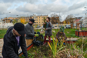 Image showing A modern family parents and children, is working together to beautify their front yard with flowers in preparation for the upcoming holiday season.