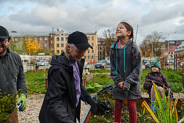 Image showing A modern family parents and children, is working together to beautify their front yard with flowers in preparation for the upcoming holiday season.