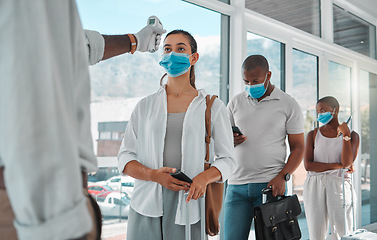 Image showing Covid safety traveling, medical doctor with thermometer testing and screening or healthcare doing protocol checkup of people at airport. Travel nurse worker scanning during the corona virus pandemic